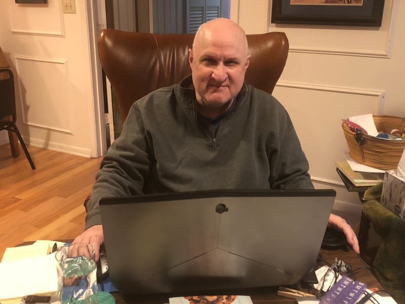心脏病幸存者蒂姆·马丁代尔博士坐在客厅的椅子上，他花了很多时间从COVID-19中恢复过来。(图片由Tim Martindale博士提供)”loading=
