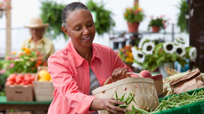 妇女在农贸市场挑选农产品