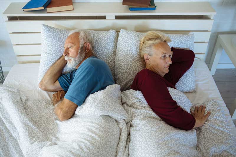 沮丧的老夫妇躺在床上