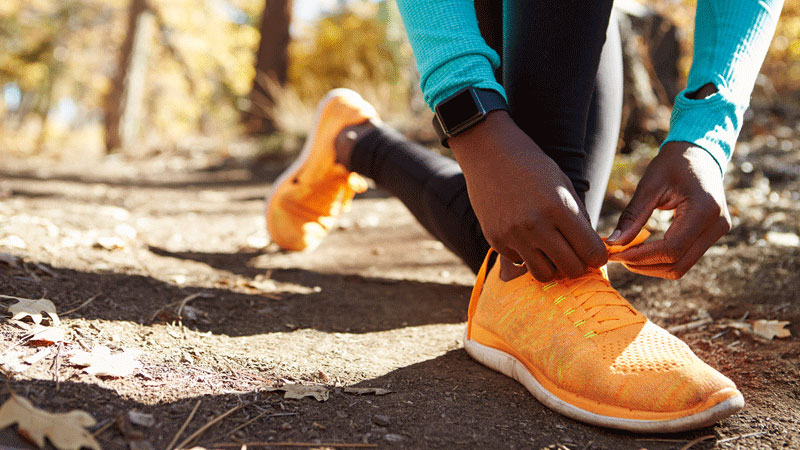 非裔美国女跑步者系着运动鞋
