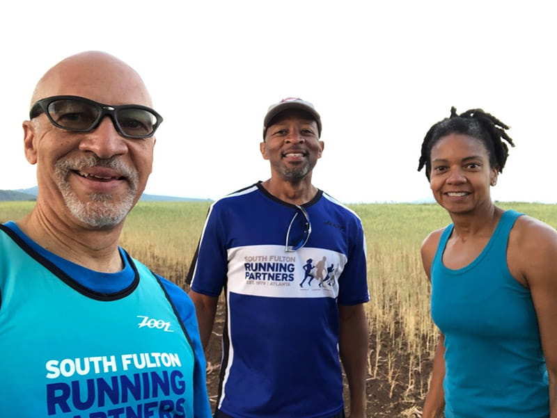 从左起:2021年7月，亚特兰大南富尔顿跑步合作伙伴的拉尔夫·莱昂斯、杰森·詹姆斯和洛里·帕尔默在坦桑尼亚进行虚拟比赛。(图片由South Fulton Running Partners提供)
