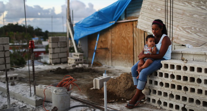 一位母亲抱着她9个月大的婴儿，三个月前飓风玛丽亚摧毁了他们在波多黎各的家
