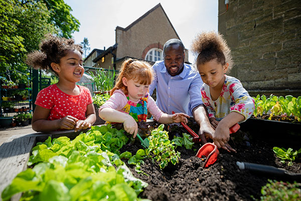 一位老师和孩子们在社区花园种植